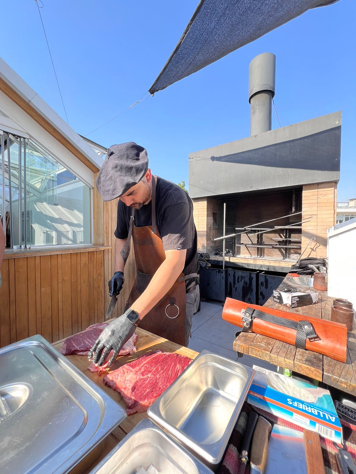 Chef preparando carnes premium en terraza