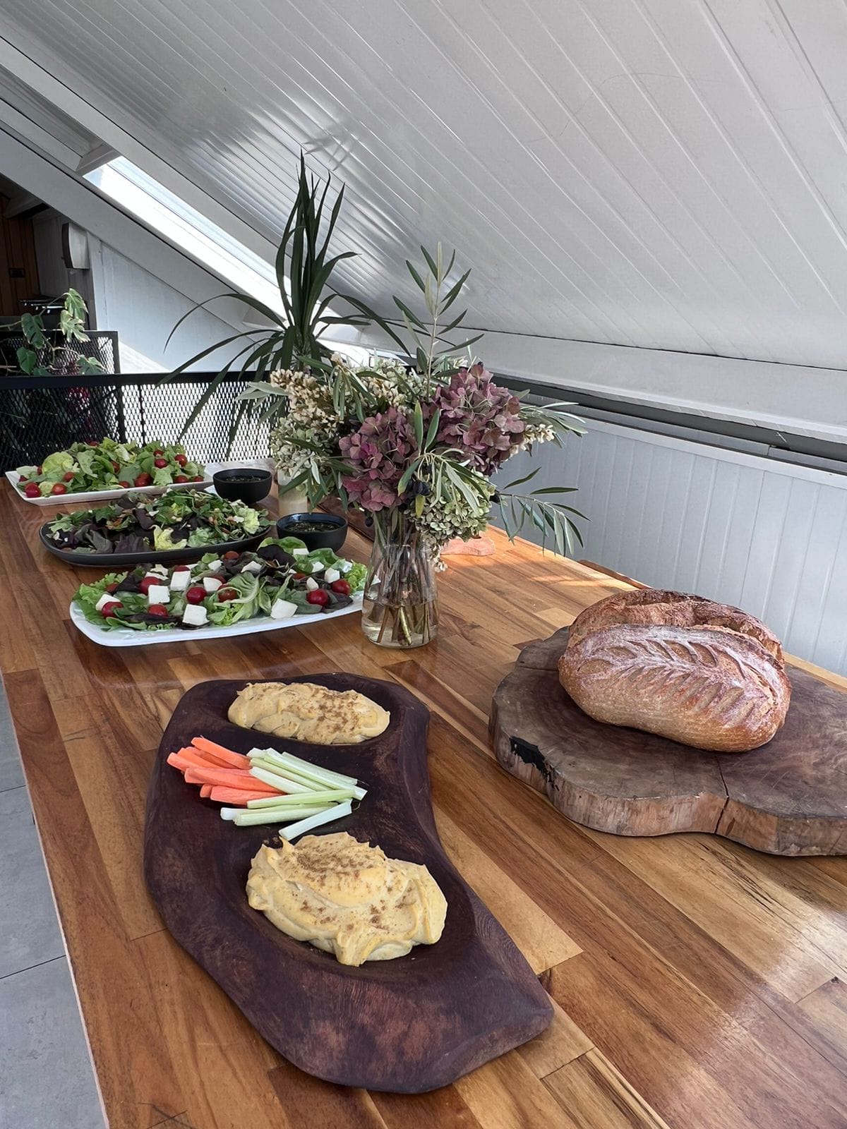 Mesa gourmet con ensaladas y pan artesanal